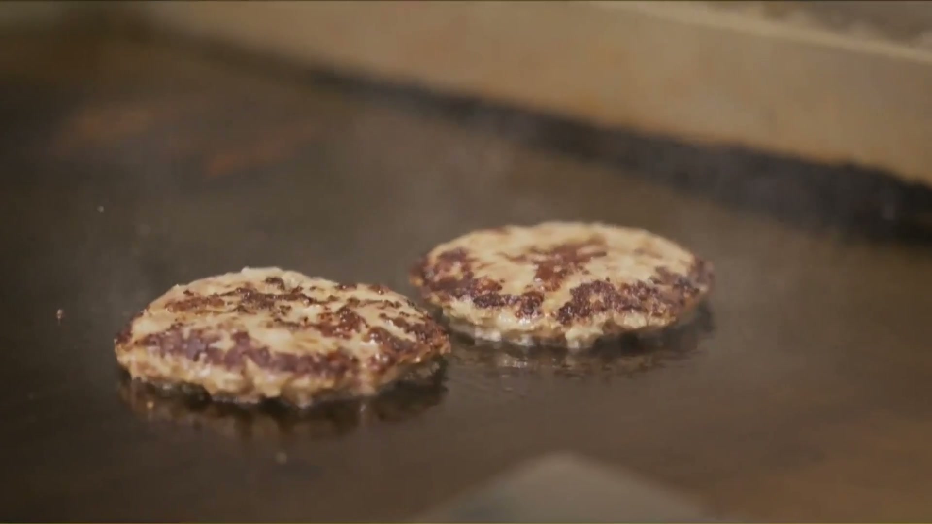 Loco Moco plate, hamburger patties on the griddle, and eggs cooking